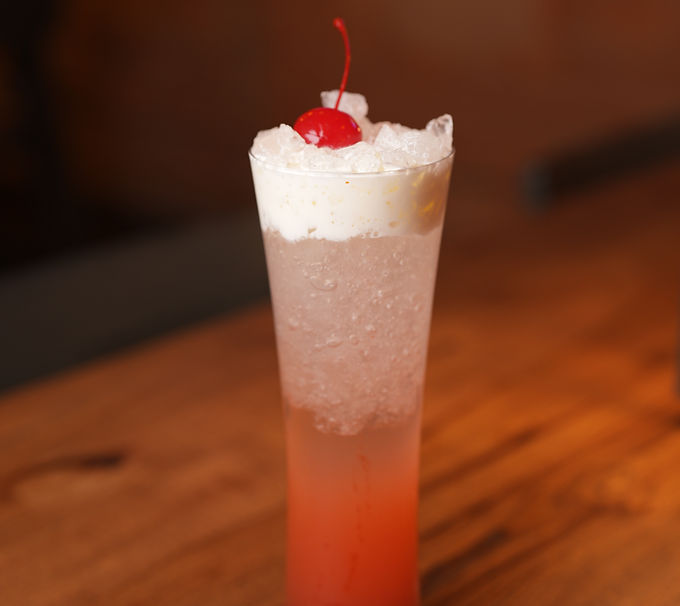 Refreshing cocktail with cherry garnish on wooden table