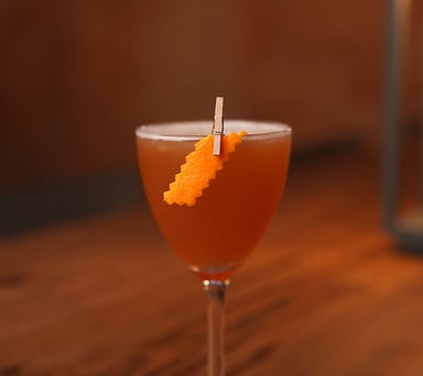Craft cocktail in a glass with orange garnish