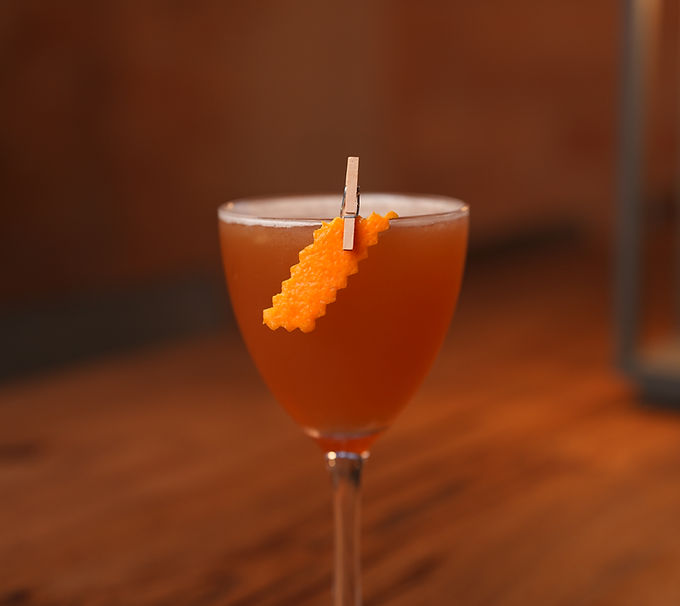 Craft cocktail in a glass with orange garnish