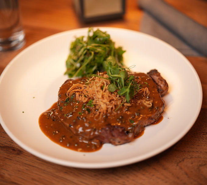 Delicious steak with savory sauce and greens.